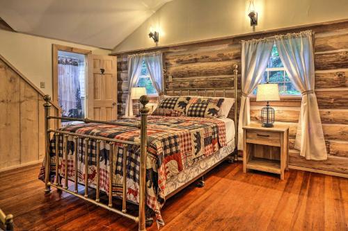 a bedroom with a bed and a wooden wall at Trails and Creek On-Site Tranquil Greentown Cabin in Greentown
