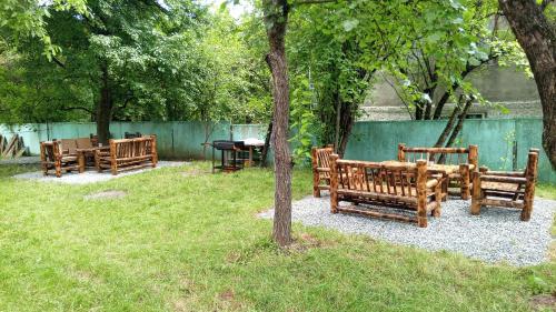 un grupo de bancos de madera sentados en un parque en Villa PorTina, en Ambrolauri