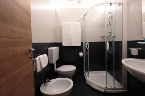 a bathroom with a toilet and a sink and a shower at Hotel Delle Nazioni - Adults Only in Caorle