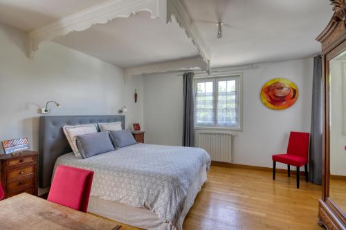 una camera da letto con un letto e due sedie rosse di Le Gite de Tournoel a Volvic