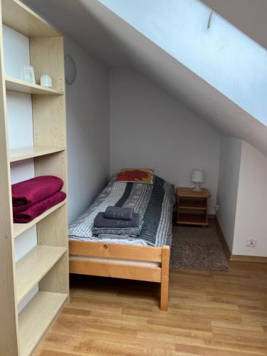 a small bedroom with a bed in a attic at Apartament Slupsk in Słupsk