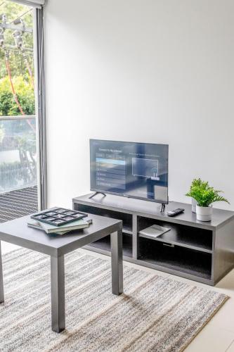 a living room with a table and a large screen tv at Del Valle Luxury Apartment in Mexico City