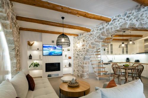 un soggiorno con parete in pietra di Petrino Two-Bedroom House in Mirthios a Plakiás