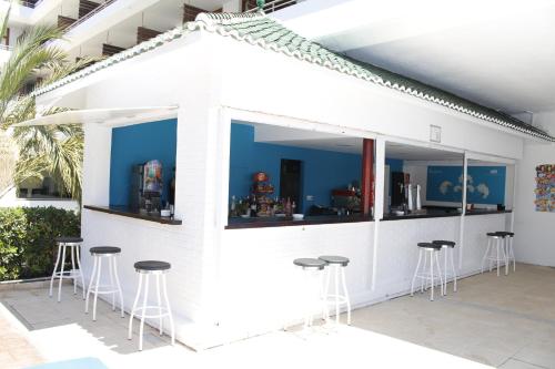 a white bar with stools in front of a building at BLUESEA Gran Cervantes in Torremolinos