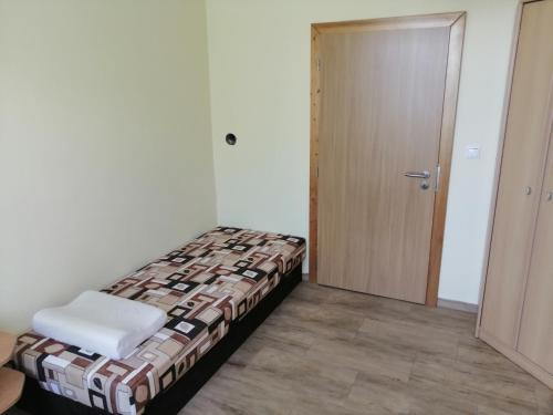 a small bedroom with a bed and a door at Apartmán Šumperk in Šumperk