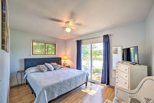 a bedroom with a bed and a tv and a window at Lakefront Wisconsin Cottage with Dock and Hot Tub! in Crivitz