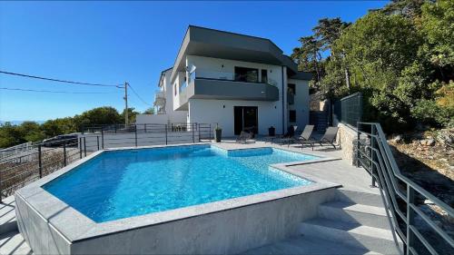 una casa con piscina frente a una casa en Vila - Mimi en Dramalj