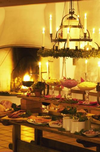 a table with many plates of food and a fireplace at Sahlströmsgården in Torsby