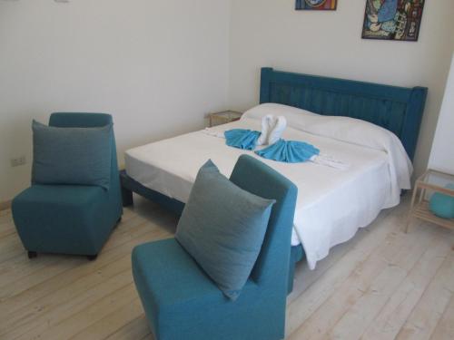 a bedroom with a bed and a blue chair at Gallipoli Al Corso in Gallipoli