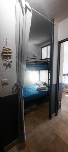 Cette chambre dispose de lits superposés et d'une fenêtre. dans l'établissement LE VALLON DU ROY plage à 600m à pieds, à Sanary-sur-Mer