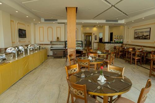 a dining room with tables and chairs in a restaurant at Tiba Rose hurghada in Hurghada