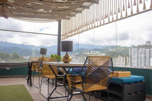 een eetkamer met stoelen en een tafel met uitzicht bij Millennials in Manizales