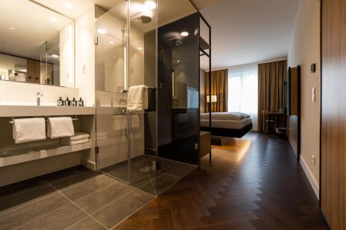 ein Bad mit einer Glasdusche und einem Bett in der Unterkunft GINN City & Lounge Yorck Berlin !New! in Berlin