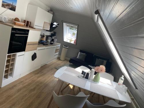 a small living room with a table and a kitchen at 38 Waldweg in Bendestorf