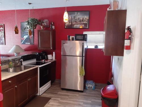 a kitchen with a stainless steel refrigerator and red walls at Baynefamilyflorida. in Fort Lauderdale