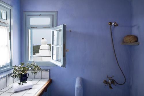 a blue bathroom with a shower and a window at Elegant island house in Khatzirádhos
