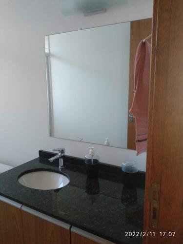 een badkamer met een wastafel en een grote spiegel bij Cs6 Casa de 3 Quartos a 15min de Curitiba in Campina Grande do Sul