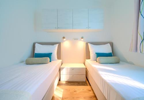 two beds sitting next to each other in a room at Holiday Homes Kanajt in Punat