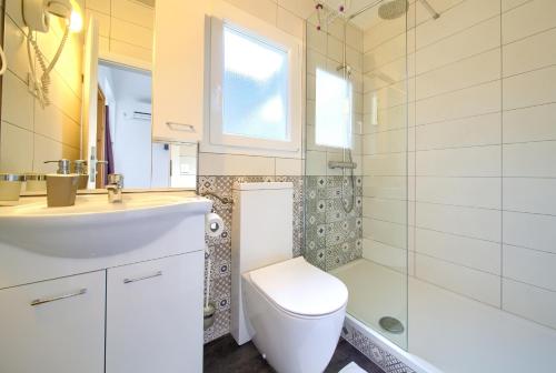 a bathroom with a toilet and a sink and a shower at Holiday Homes Kanajt in Punat