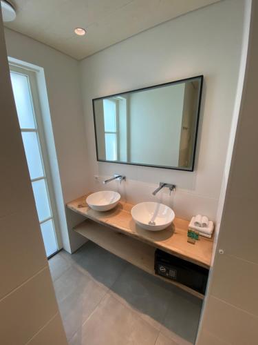 uma casa de banho com 2 lavatórios e um espelho grande em Slot Oostende em Goes