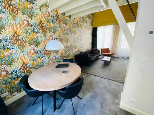 a room with a table and chairs and a mural at Slot Oostende in Goes