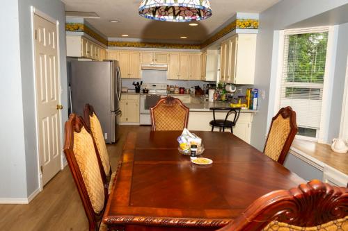 a kitchen with a table and chairs and a refrigerator at Anita's Bed & Breakfast - Bedroom On Ground Floor With Backyard in Abbotsford