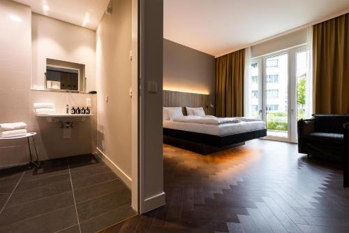 a bedroom with a bed and a living room at GINN City & Lounge Yorck Berlin in Berlin