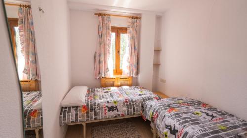 a bedroom with two twin beds and a window at Apartamentos Formigal - admite mascotas in Formigal