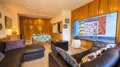 a living room with a couch and a large screen at Apartamentos Formigal - admite mascotas in Formigal