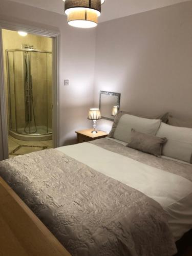 a bedroom with a large bed and a shower at Coastal townhouse Belmullet in Belmullet