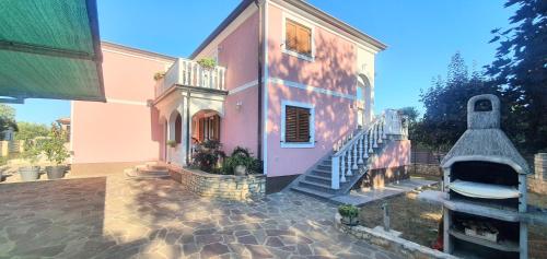 a house with a staircase leading up to it at Apartmani Radmila in Nova Vas