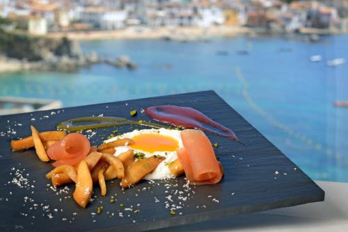 a plate of food with eggs and vegetables on a table at Hotel Sant Roc in Calella de Palafrugell
