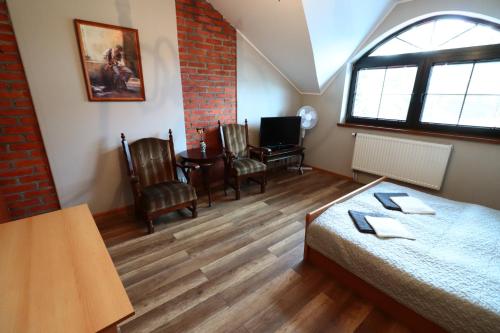 a room with a bed and a table and chairs at Karczma Pod Jesionem in Brdów