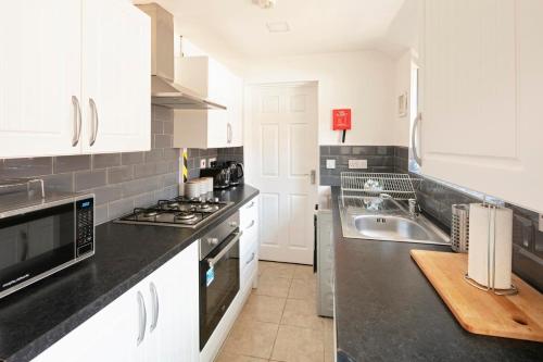 Køkken eller tekøkken på Coventry Large Sleeps 5 Person 4 Bedroom 4 Bath House Suitable for BHX NEC Solihull Rugby Warwick Contractors Ricoh Arena NHS Short & Long Business Stays Free Parking for 2 Vehicles, Close to City Centre High Speed Wifi