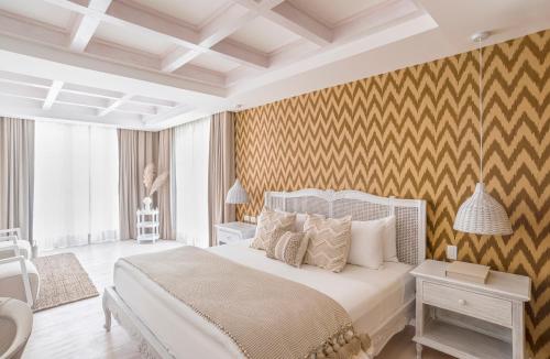 a bedroom with a white bed and a yellow wall at Villa Bokeh Relais & Châteaux in Antigua Guatemala