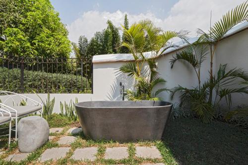 a bath tub with a palm tree in a garden at Villa Bokeh Relais & Châteaux in Antigua Guatemala