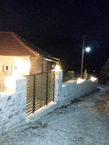 a house with a fence and a street light at night at ΕΚΑLI ROOMS APARTMENTS in Kalentzi