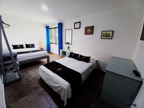 a bedroom with two beds and a table in it at RCH Suite in Mexico City