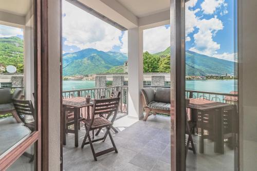 a balcony with tables and chairs and a view of the water at Stunning view lakeside apartment - Larihome A11 in Gravedona