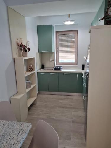 a kitchen with green cabinets and a sink and a window at Matteo 2 Apartments Marina Surf Residence, Mamaia Nord - Năvodari,1 vedere frontala,2 cu vedere laterala la mare in Năvodari