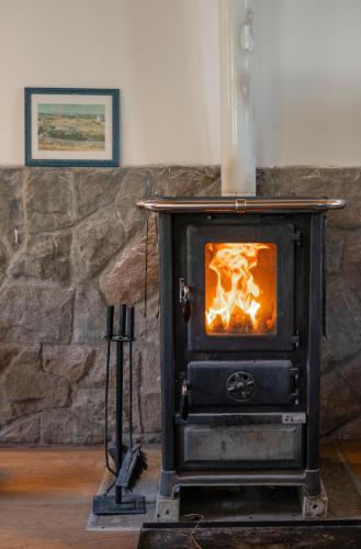 a stove in a room with a stone wall at Kuca pod Rudnikom in Trudelj