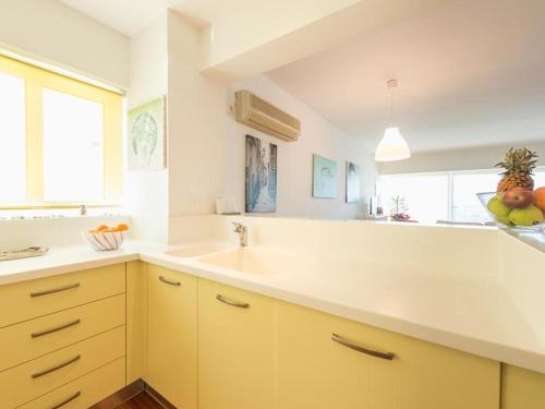 a kitchen with yellow cabinets and a sink at Amazing Beach Apt Panoramic View next to Marina Alimos in Athens