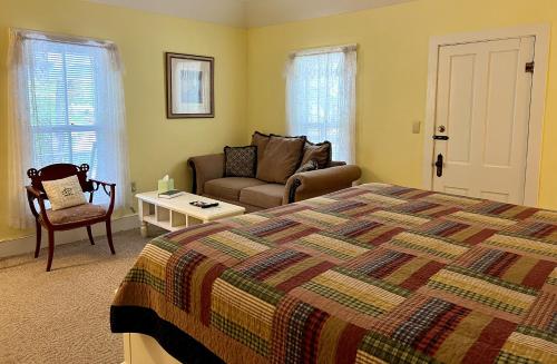 a bedroom with a bed and a couch and a table at Ozark Country Inn in Mountain View