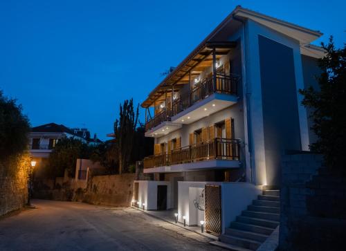 a house with stairs and a balcony at night at IONIS Apartments in Preveza