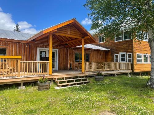 a large wooden cabin with a large deck at Air-Dale Lodge in Hawk Junction