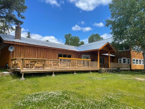 une grande maison en bois avec une grande terrasse dans l'établissement Air-Dale Lodge, à Hawk Junction