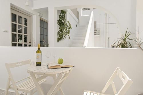 a table and chairs with a bottle of wine and a book at Argo Boutique Hotel in Naxos Chora