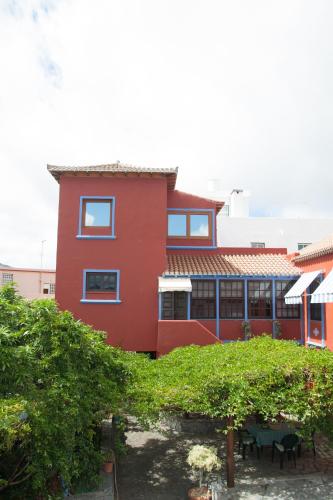 a red building with a garden in front of it at Villa Perestelo in Los Sauces