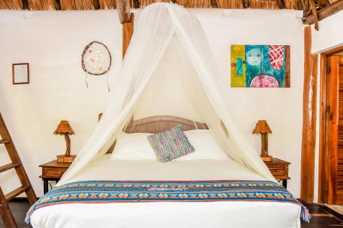 a bedroom with a bed with a canopy at Zomay Beachfront Holbox in Holbox Island