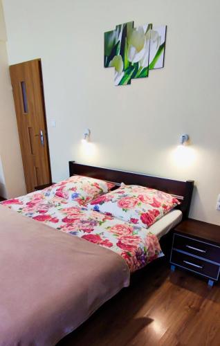 a bedroom with a bed with a floral bedspread at Pokoje Gościnne Sonea in Lewin Kłodzki